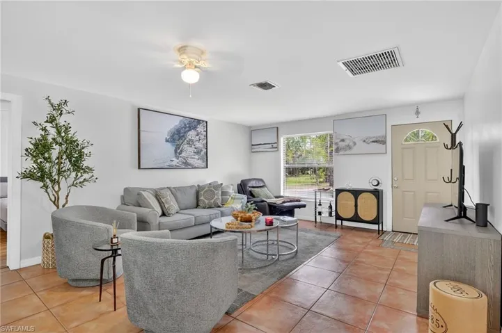 Living room featuring light tile patterned floors and ceiling fan