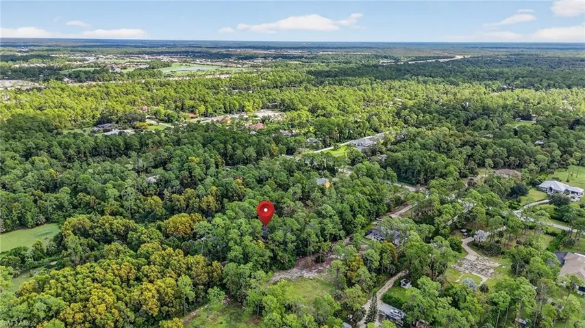 Aerial view of property and surrounding area featuring a heavily wooded area