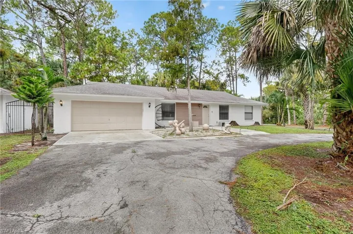 Ranch-style home with driveway, an attached garage, and stucco siding