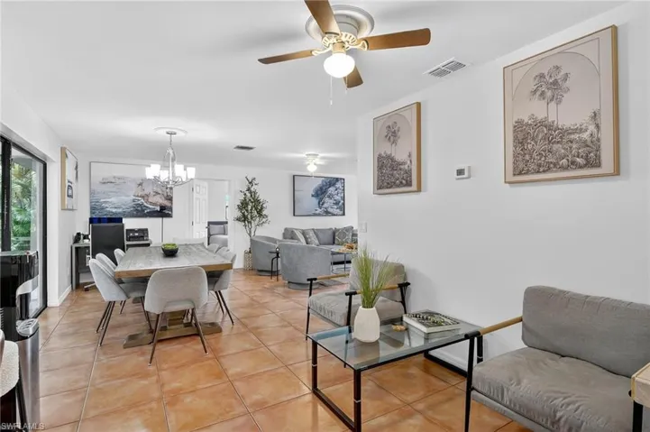 Dining space featuring light tile patterned floors, a ceiling fan, and a chandelier