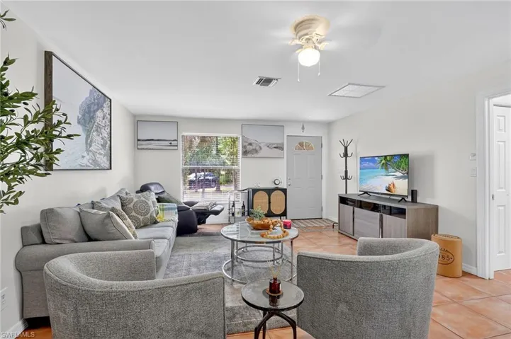 Living area featuring light tile patterned floors and ceiling fan