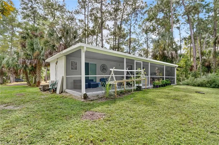 View of front of home with a front lawn, a sunroom, and stucco siding