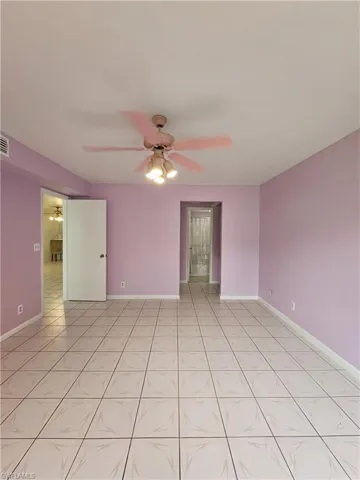 Spare room with ceiling fan and light tile patterned flooring