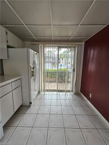 Unfurnished dining area with floor to ceiling windows and light tile patterned floors