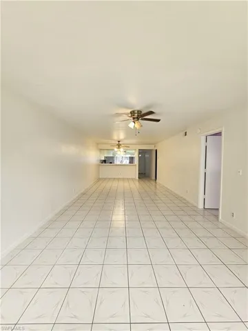 Unfurnished living room featuring ceiling fan and light tile patterned floors