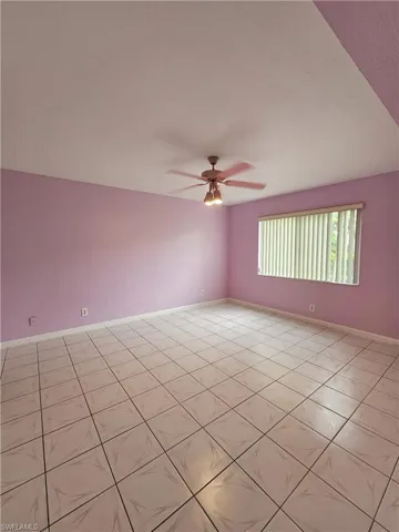 Empty room featuring ceiling fan and light tile patterned floors