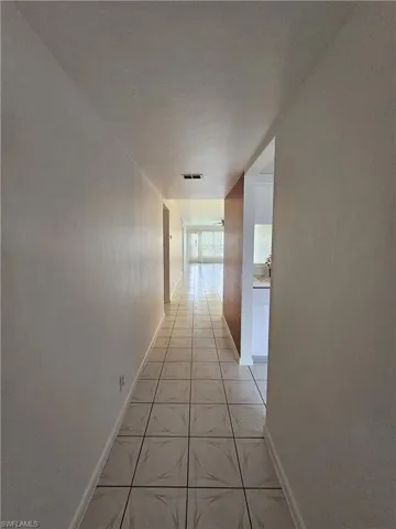 Corridor with light tile patterned floors and baseboards