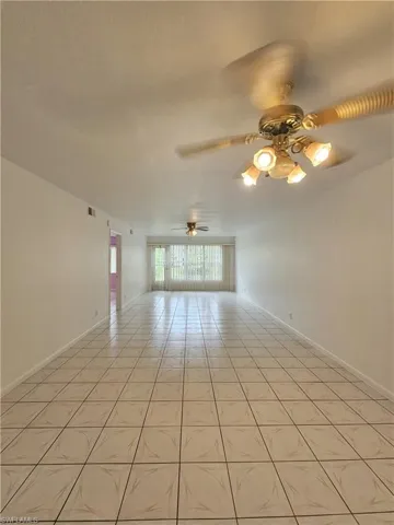 Spare room with ceiling fan and light tile patterned floors