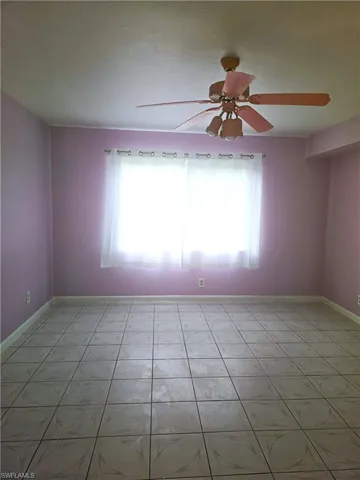 Unfurnished room with baseboards and a ceiling fan