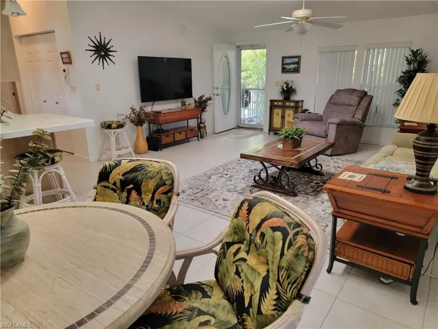 Living area featuring light tile patterned floors and a ceiling fan