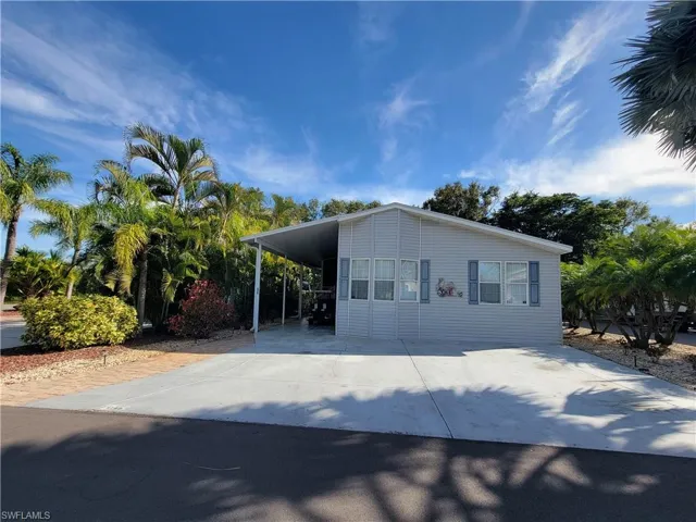 View of front facade featuring an attached carport and driveway