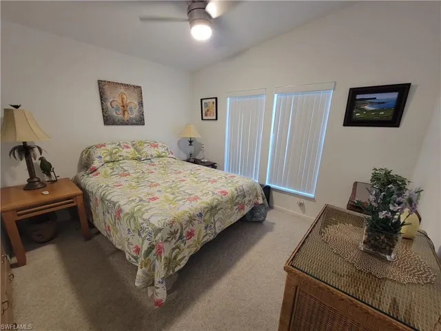 Bedroom with lofted ceiling, carpet, and ceiling fan