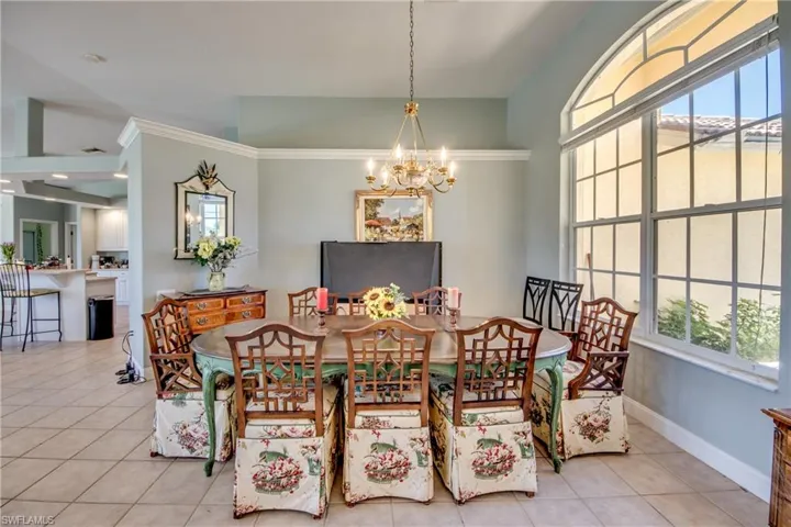 Large dining room has lots of light coming in through the dual windows and accented by the arched window above.