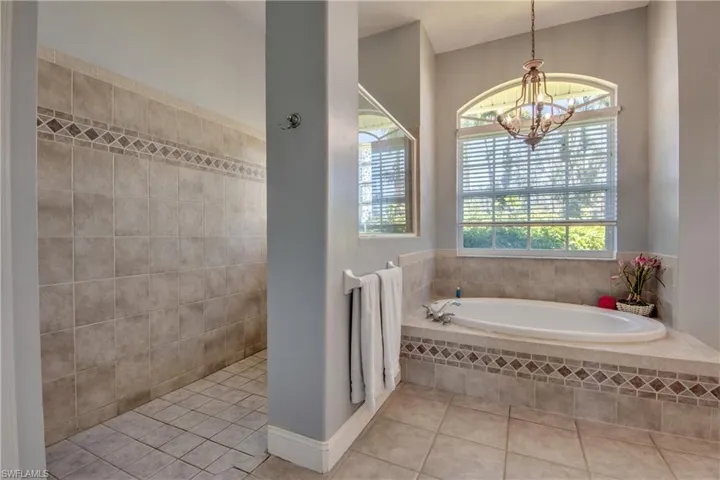 Primary ensuite bathroom features tiled walk-in shower and jetted soaker tub. There is also a linen closet to the left of the shower.