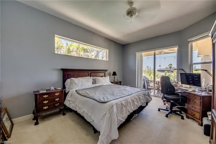 Primary bedroom has multiple windows and access to the lanai & pool via the sliders that stack behind the wall.