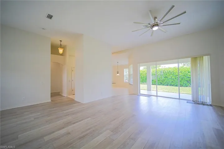 The Oversized Living Room Has Gray Wood Plank Flooring, New Ceiling Fan/Light, New Paint Throughout The Entire House, And A Triple Slider That Leads Out To The Covered Lanai!