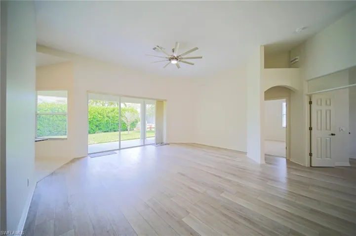 The Oversized Living Room Has Gray Wood Plank Flooring, New Ceiling Fan/Light, New Paint Throughout The Entire House, And A Triple Slider That Leads Out To The Covered Lanai!