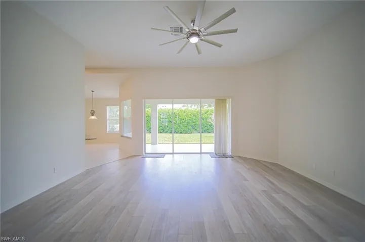 The Oversized Living Room Has Gray Wood Plank Flooring, New Ceiling Fan/Light, New Paint Throughout The Entire House, And A Triple Slider That Leads Out To The Covered Lanai!