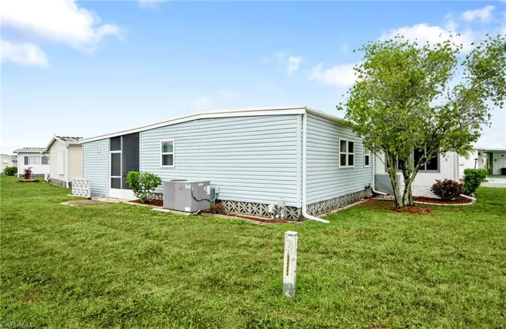 Back of house featuring central AC unit and a yard
