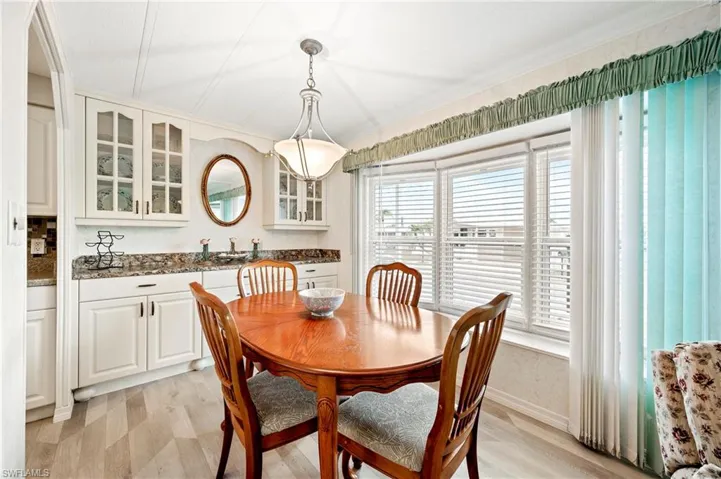 Dining area with healthy amount of natural light, light wood-type flooring, and baseboards