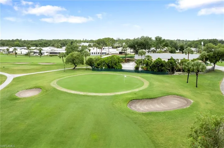 View of community with view of golf course, an area to practice putting, and view of scattered trees