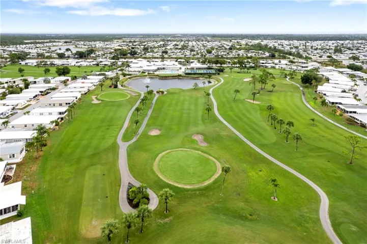 Aerial overview of property's location featuring a large body of water, nearby suburban area, and a golf course