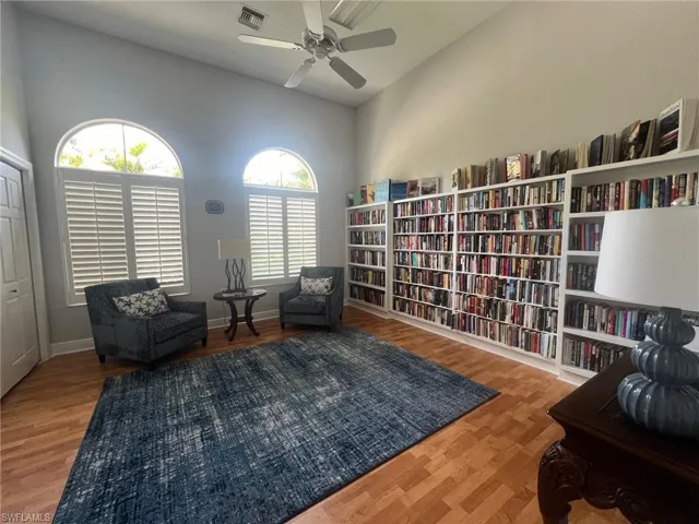 Library/Sitting room featuring a towering ceiling and wood-type flooring