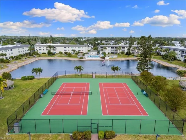 View of tennis court featuring a water view