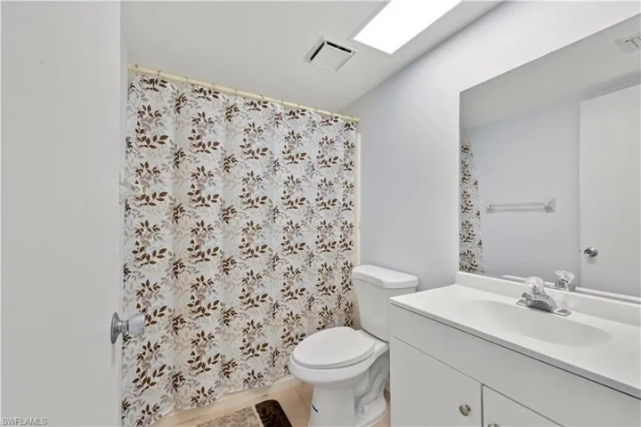 Bathroom with vanity and curtained shower