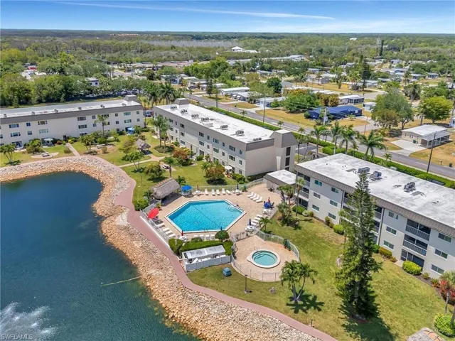Drone / aerial view of a pool area and a large body of water