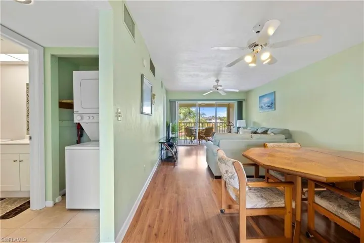 Dining room featuring estacked washer and dryer, ceiling fan, and light wood-type flooring