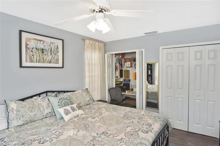 Bedroom featuring two closets, dark wood finished floors, and ceiling fan
