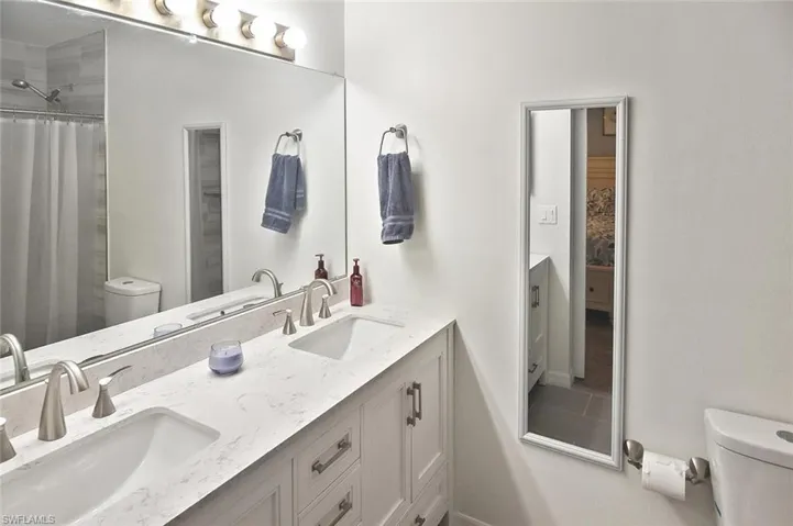 Bathroom with double vanity and curtained shower