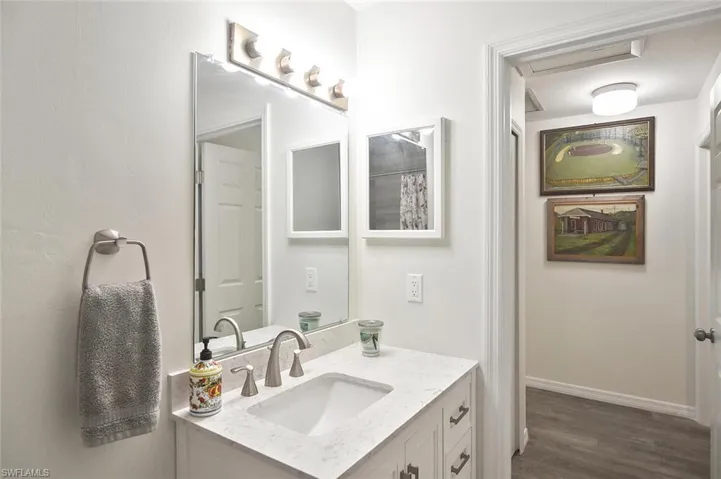 Bathroom featuring vanity, a shower with curtain, and dark wood-type flooring