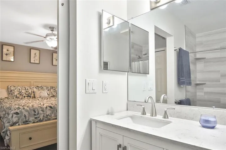 Ensuite bathroom featuring vanity, a shower with shower curtain, and a ceiling fan