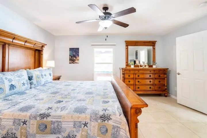Tiled bedroom featuring ceiling fan