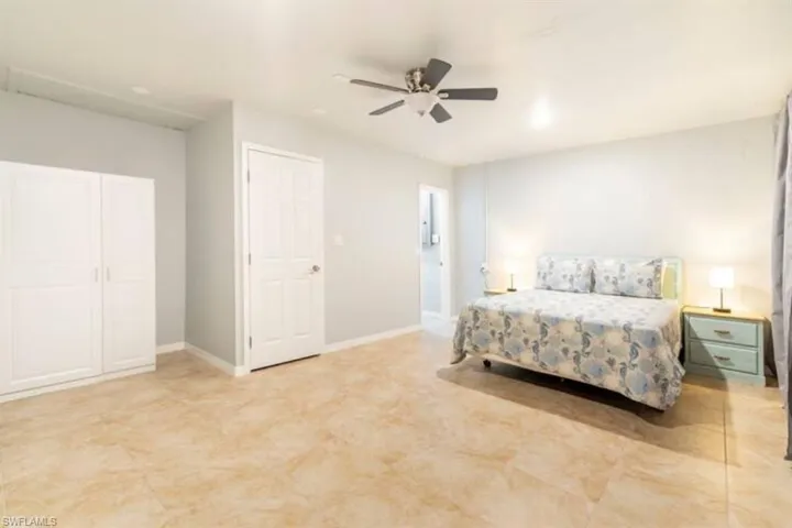 Bedroom with ceiling fan and light tile patterned floors