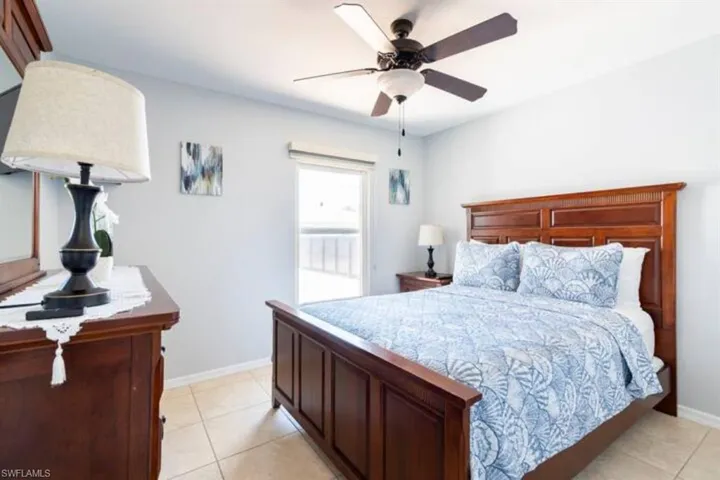 Tiled bedroom featuring ceiling fan