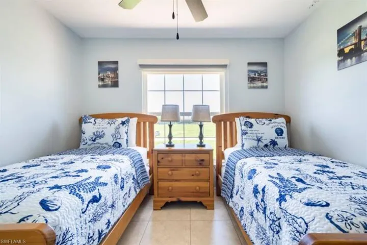 Tiled bedroom featuring ceiling fan