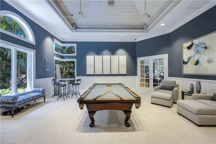 Alongside the kitchen/family room is a dedicated game room with wood paneled ceilings. Relax and enjoy!
