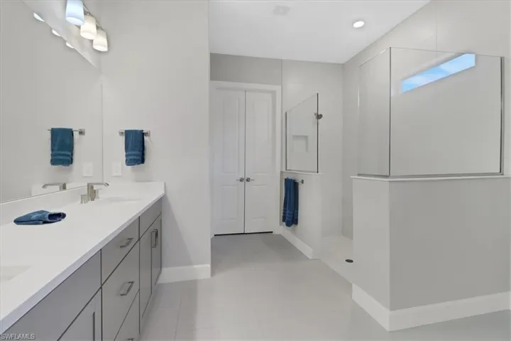 Bathroom with vanity, tile patterned floors, and walk in shower