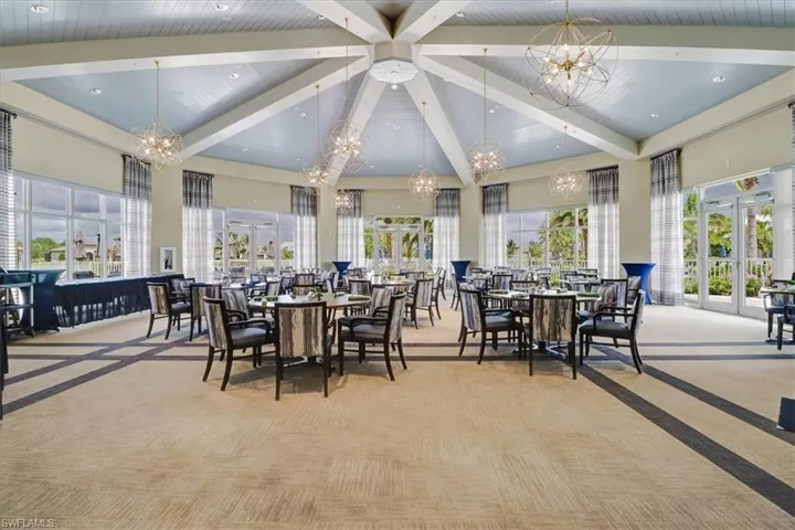 Carpeted dining space featuring wood ceiling, beam ceiling, an inviting chandelier, high vaulted ceiling, and french doors