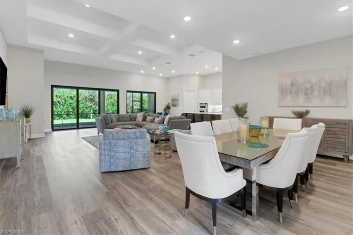 Formal dining room featuring coffered ceiling, beamed ceiling, and luzury vinyl flooring