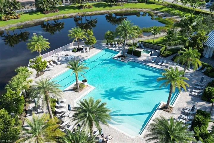 View of swimming pool with a water view and a patio area