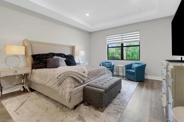 Bedroom with a tray ceiling and luxury vinyl flooring