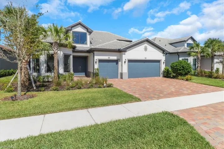 View of front of property featuring a front lawn and a garage