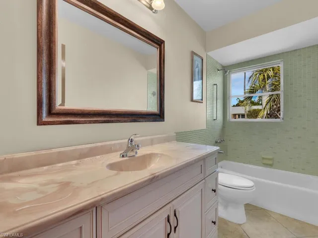 Bathroom featuring vanity, bathing tub / shower combination, and light tile patterned floors
