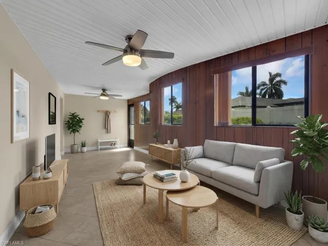 Living room with wood walls, a ceiling fan, and wood ceiling