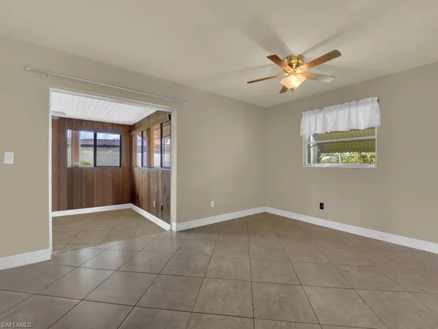 Spare room with ceiling fan, plenty of natural light, and light tile patterned floors