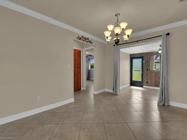 Unfurnished dining area featuring suspended lighting, ornamental molding, ceiling fan, and light tile patterned flooring